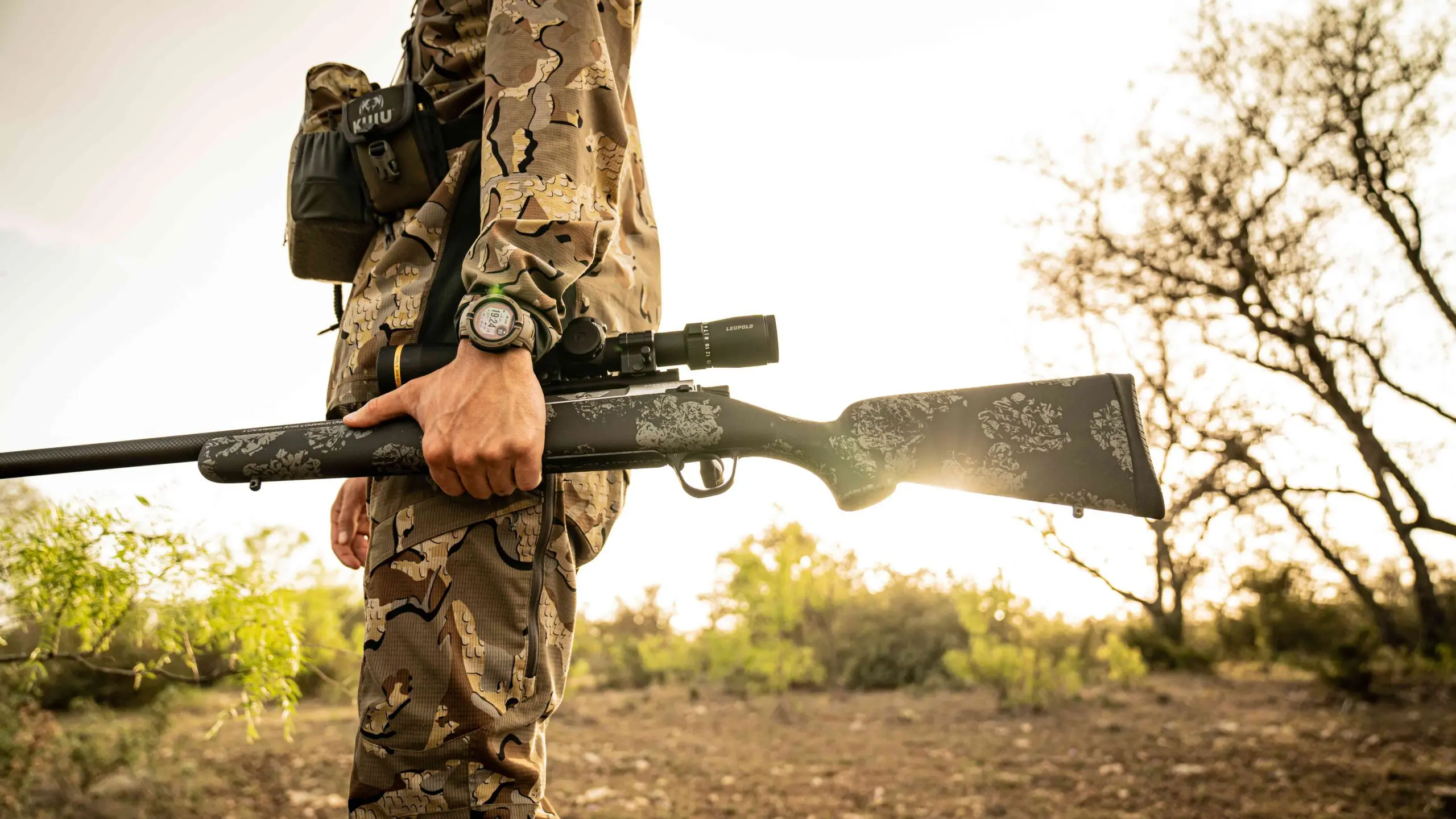 Hunter carrying a Christensen Arms rifle with a carbon fiber stock in the field
