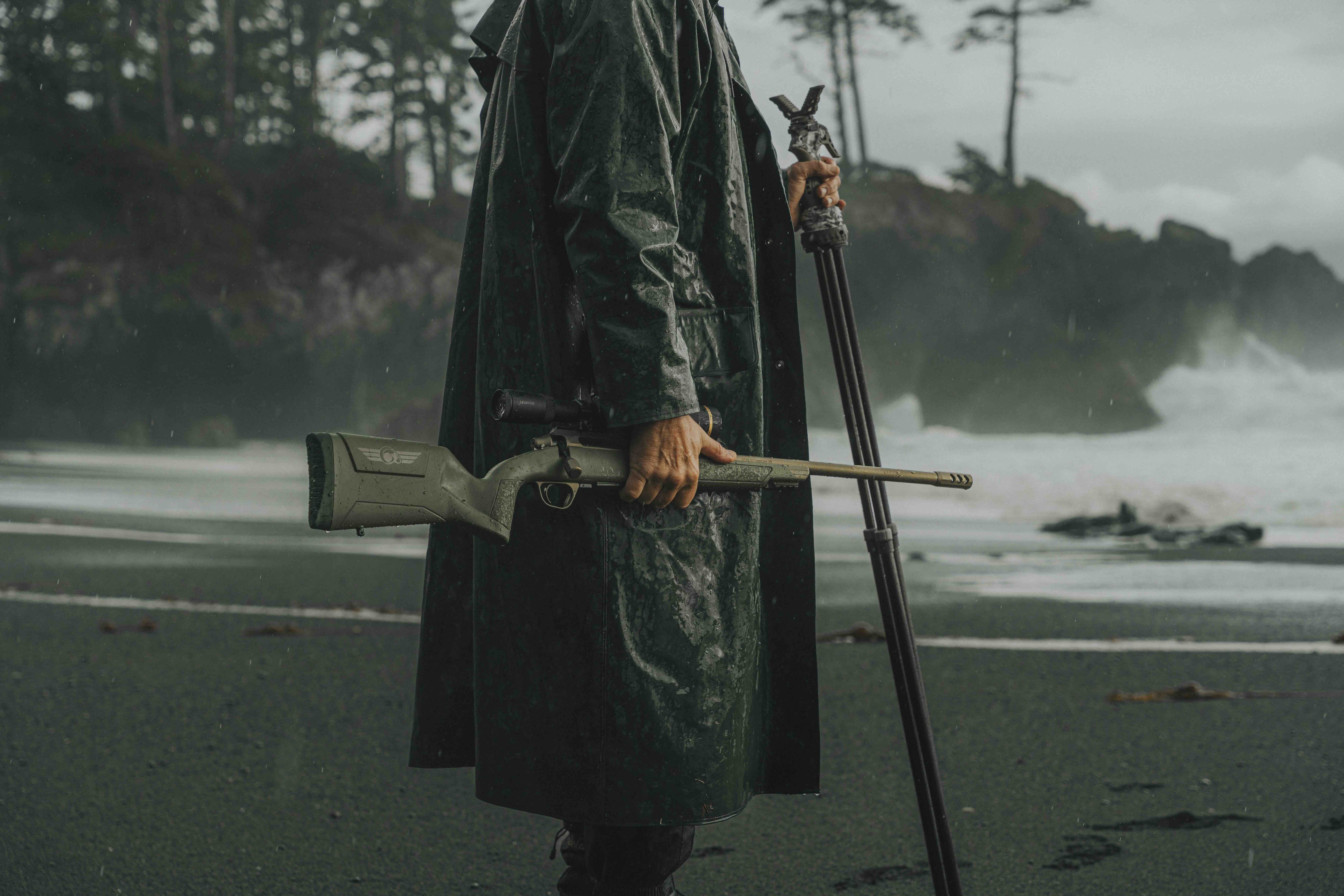 Hunter carrying a weather-resistant Evoke hunting rifle in wet coastal conditions