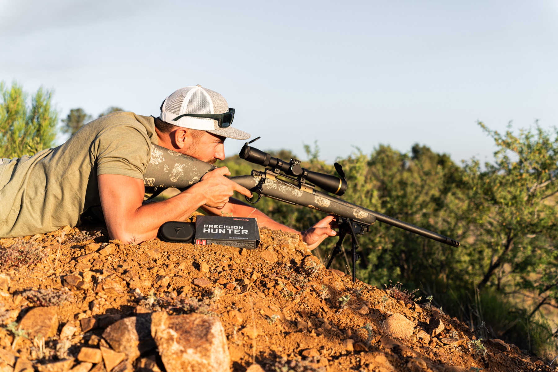 Hunter shooting a Christensen Arms rifle from a bipod-supported field position