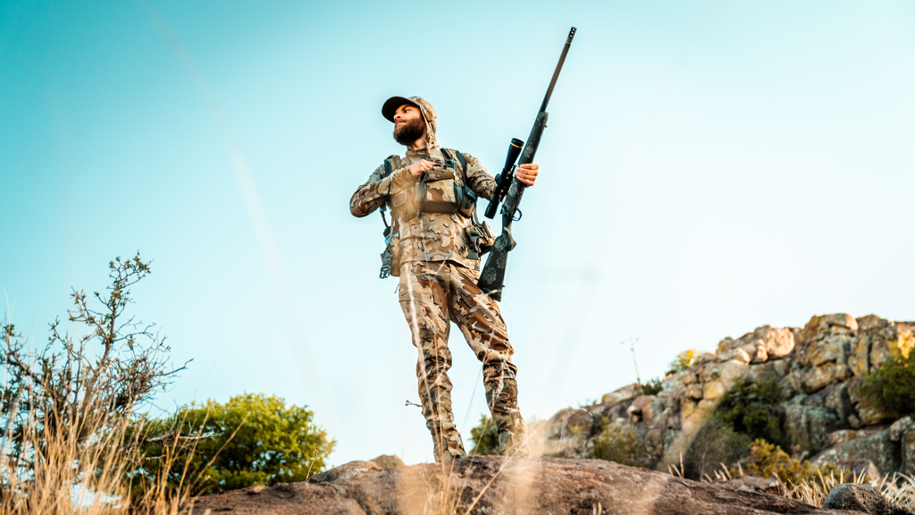 Hunter carrying a Ridgeline FFT carbon fiber hunting rifle in mountain terrain